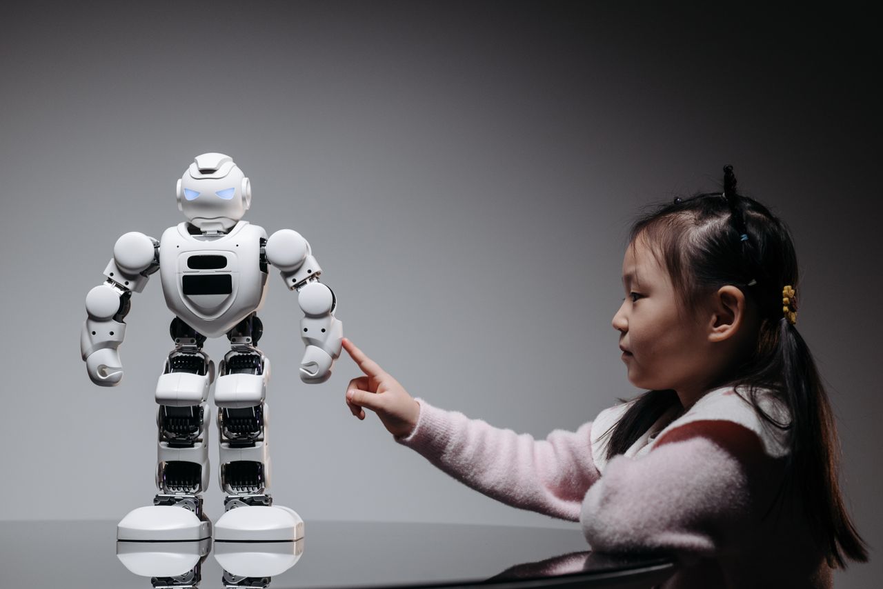 Home A young girl engaging with a robotic toy, highlighting curiosity and innovation.