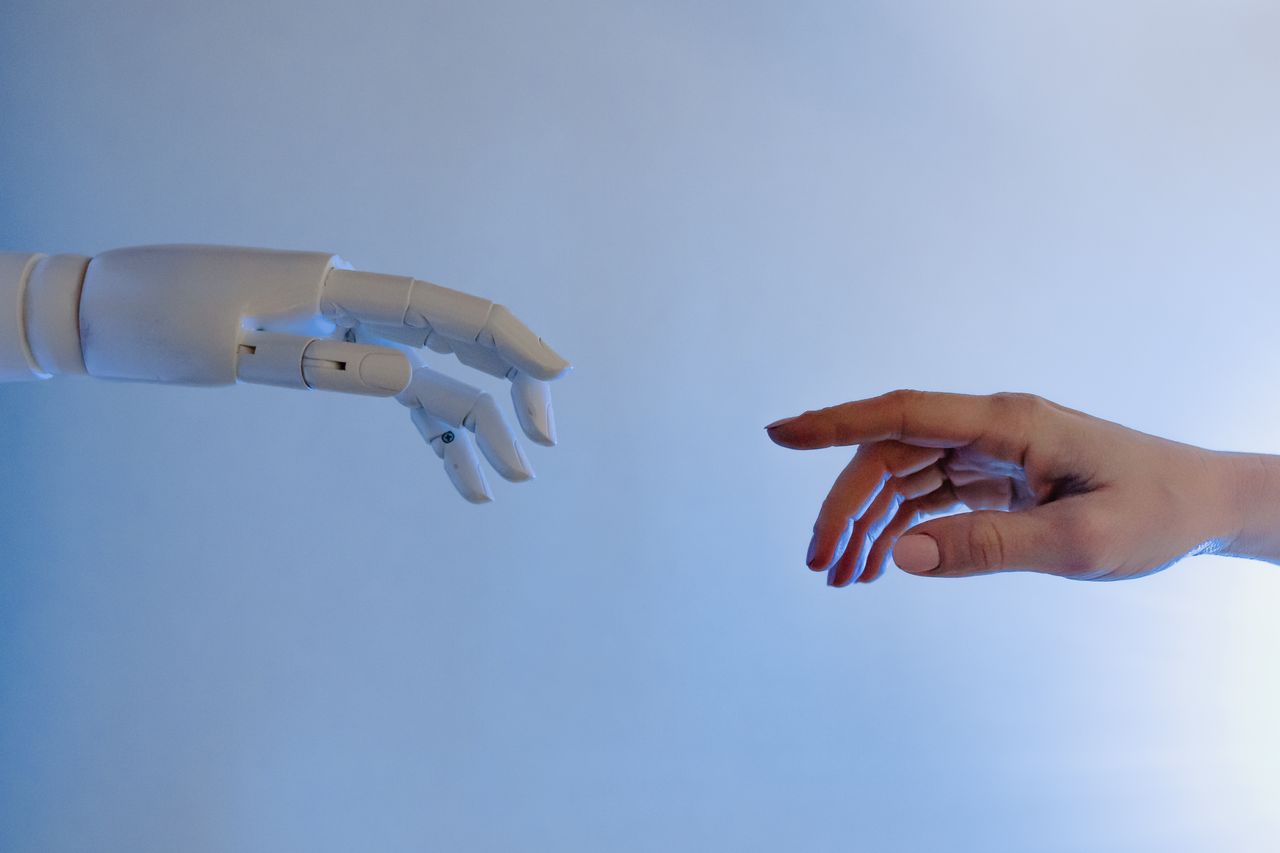 Mastering the First Impression: Your intriguing post title goes here A human hand reaching towards a robotic hand symbolizing technology and connection.